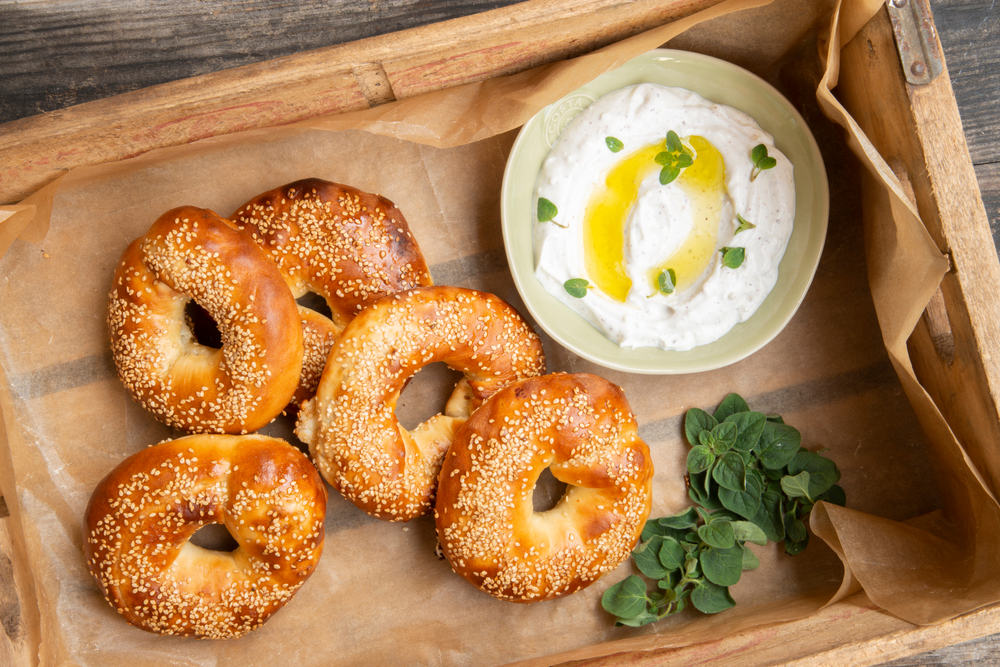 Jerusalem Bagel Stuffed With Fete Cheese and Zaatar and Plate of Labneh Cheese In a Wooden Crate