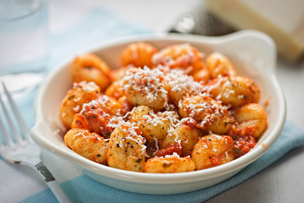 Gnocchi with tomato sauce and parmesan. It's served in a white serving dish