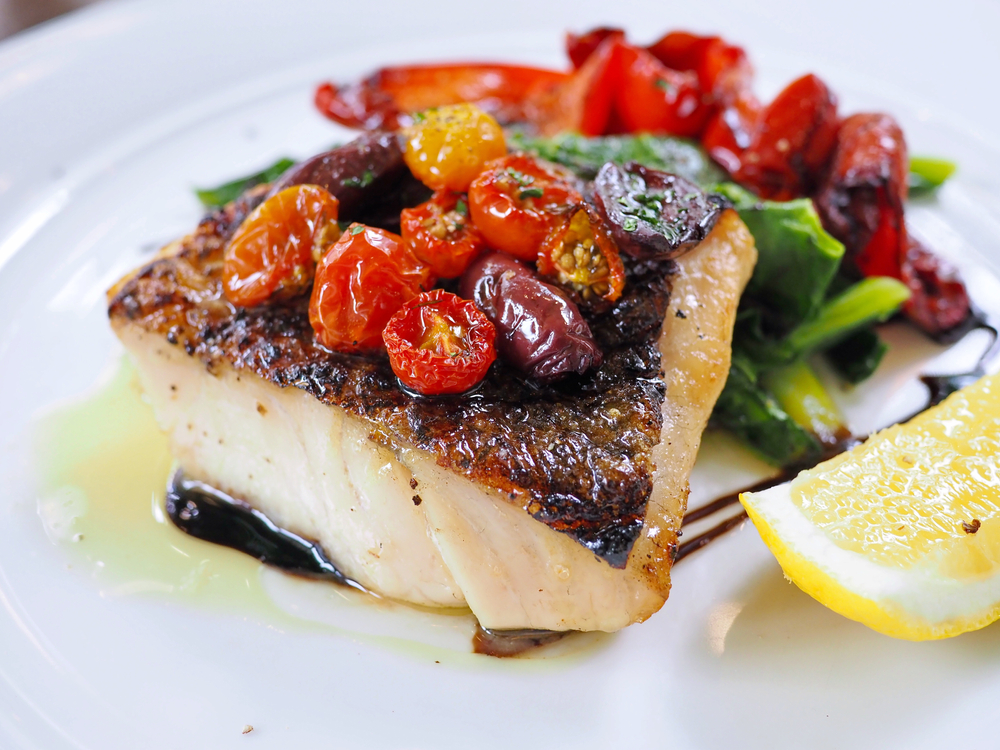 seabass with dark skin served with colorful assorted grilled vegetables red bell pepper drizzled with balsamic vinegar in an article about restaurants in Chicago