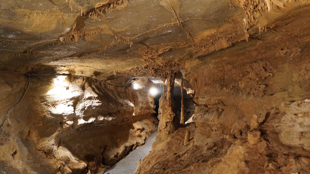 The inside of a large cavern that has a walkway and lights