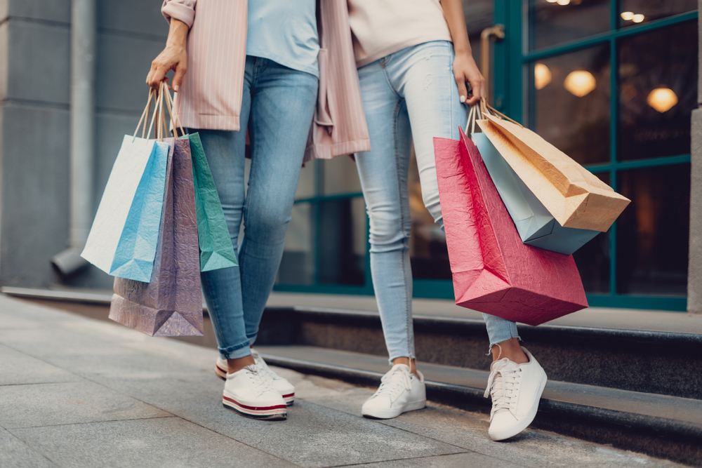 Cropped portrait of young lady and her mother holding colorful shopping bags. Shopping is one of the things to do in Lancaster 