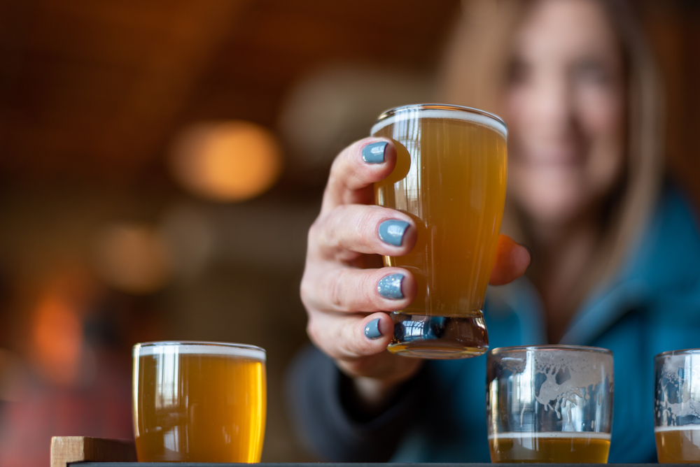 Closeup of a glass of craft beer with woman holding it breweries in Milwaukee
