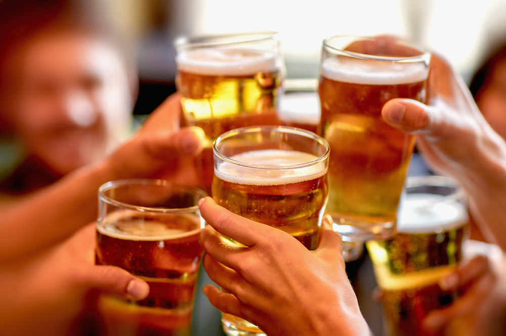 Closeup of people celebrating with beer glasses
