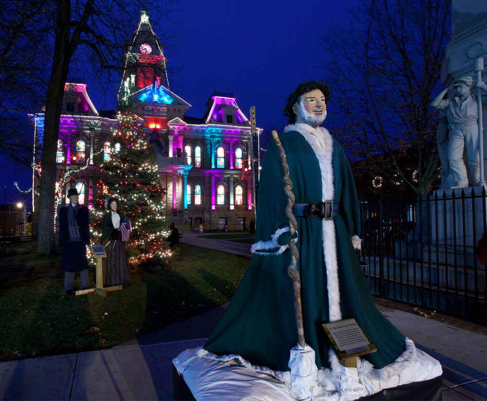 A mannequin in Victorian period clothing in front of a historic building in the Dickens Victorian Village during winter in Ohio