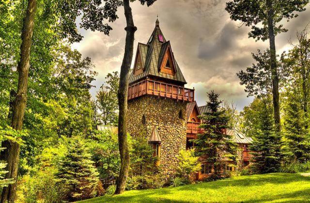 A stone castle surrounded by trees on a cloudy day that is actually one of the best resorts in Ohio