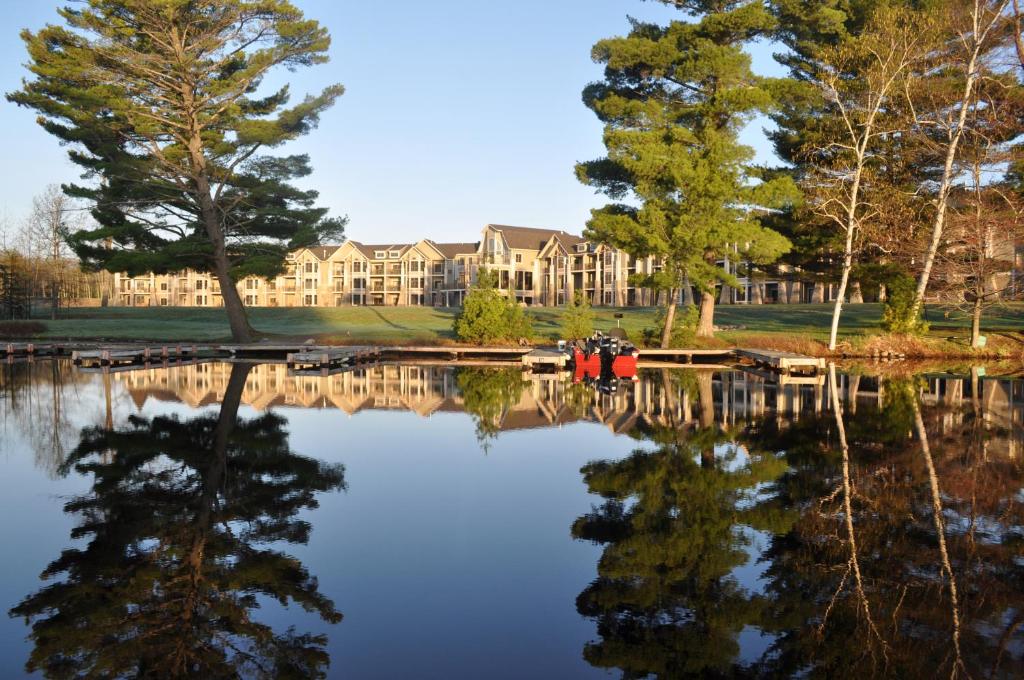 A large building on the edge of a lake on a sunny day that is one of the best resorts in Wisconsin