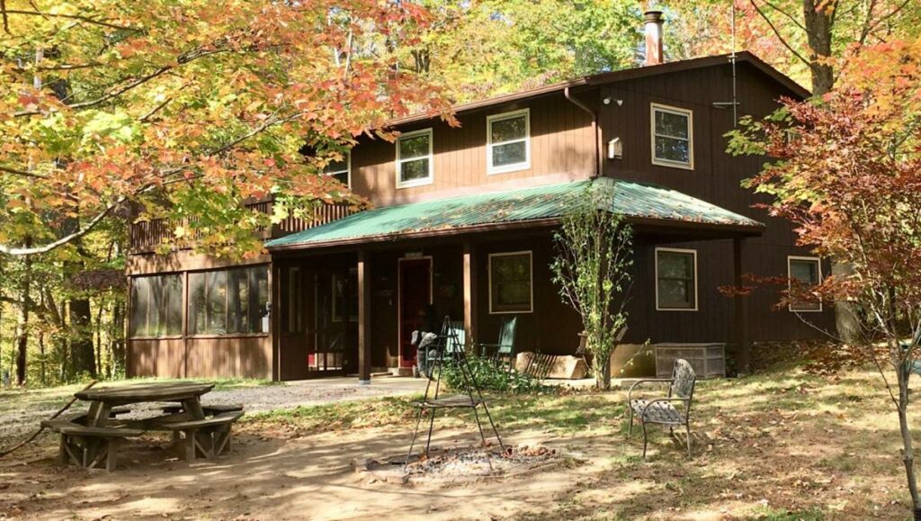 A brown lodge in the middle of the woods during the fall