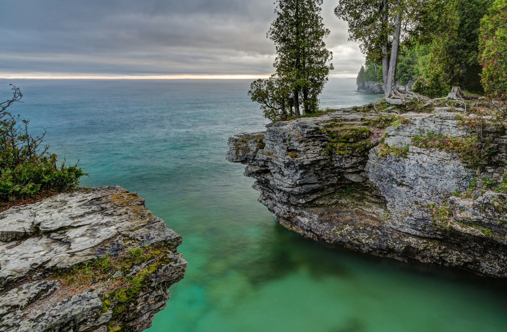 The rocky coast of Door County, Wisconsin's Cave Point displays beautiful colors in the light of a stormy sunrise