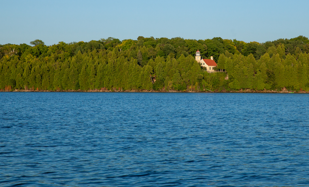 Eagle Point Lighthouse and Peninsula State Park shot from the water on boat. The article is about towns in door county