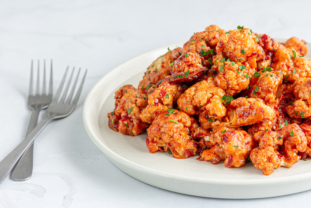 Cauliflower wings on a white plate in an article about vegan restaurants in Chicago