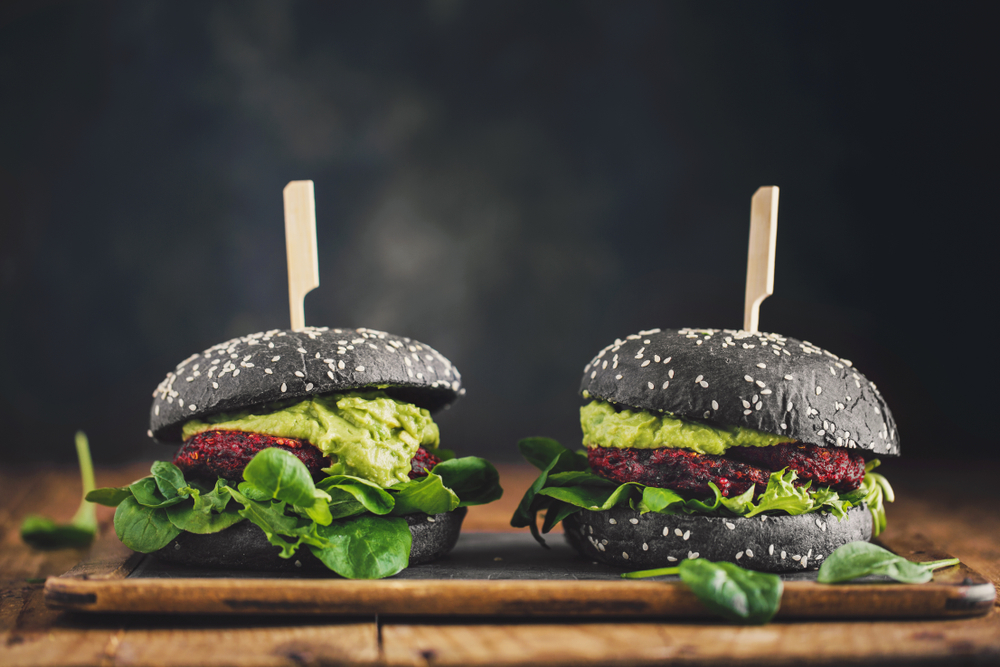 Two burgers in black buns on a table in an article about vegan restaurants in Chicago