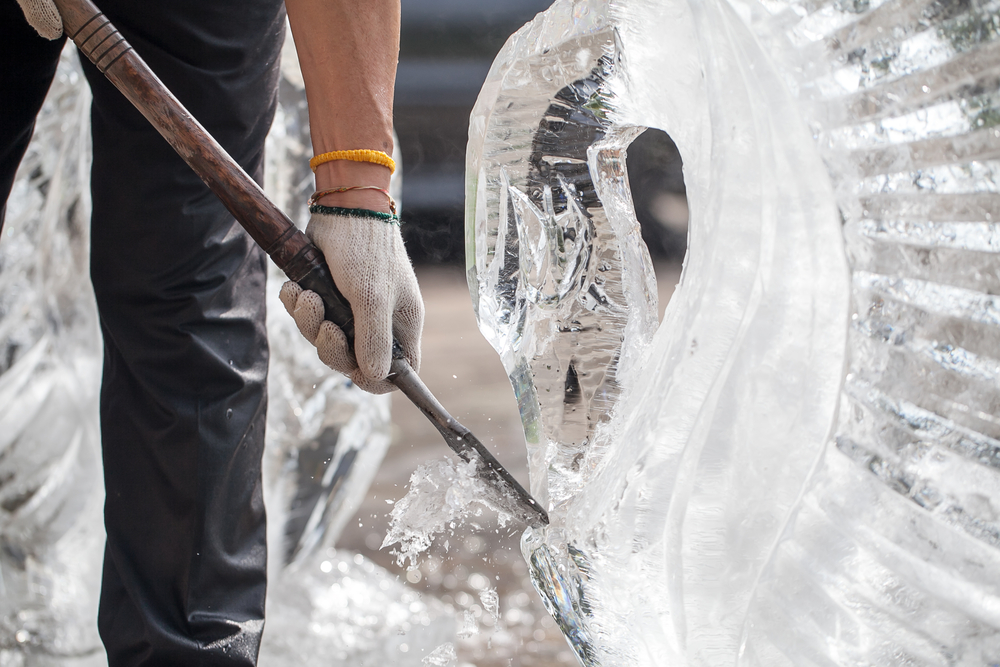 man is carving the ice sculpture into a shape of a swan. The article is about winter in Door County 