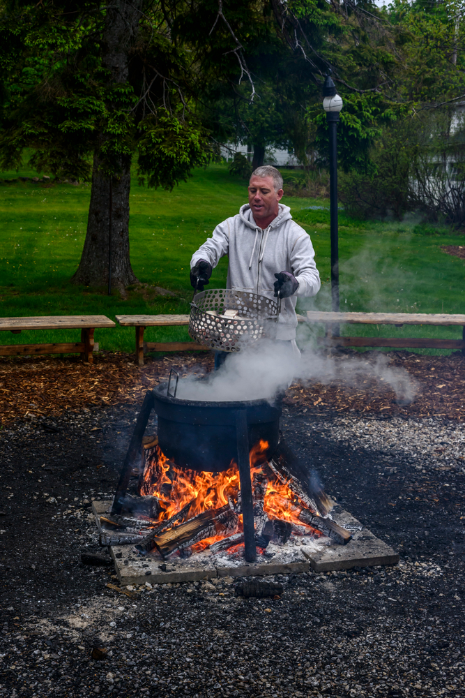 Man holds up a tub of whitefish for fish boil at the