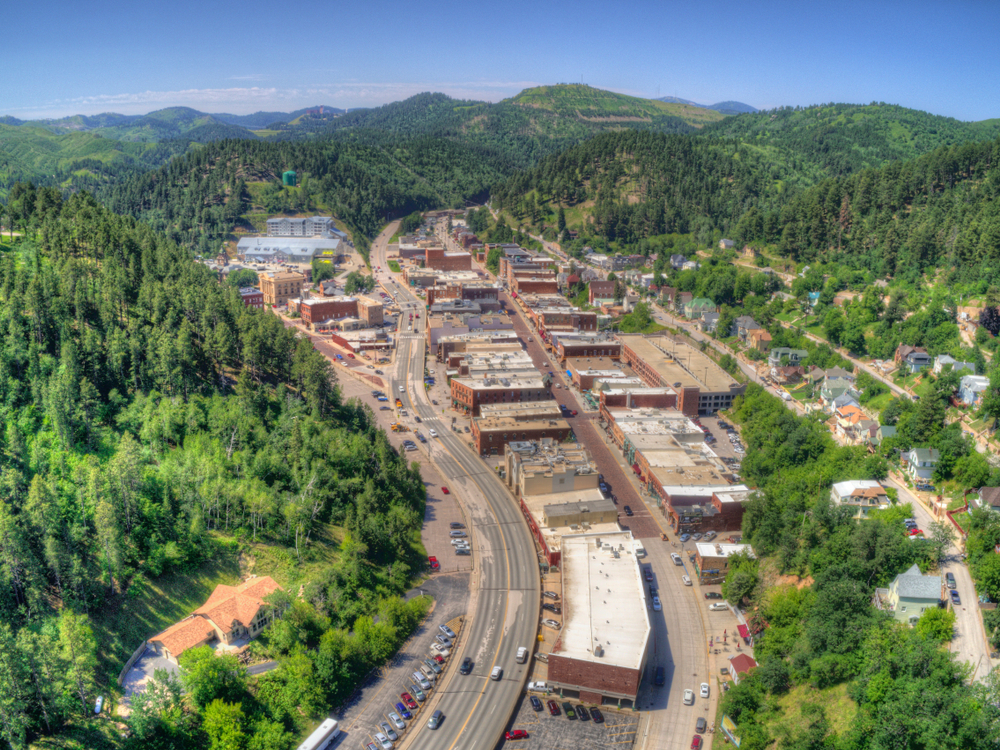 Aerial view of the town of Deadwood nestled in the greenery of the Black Hills.