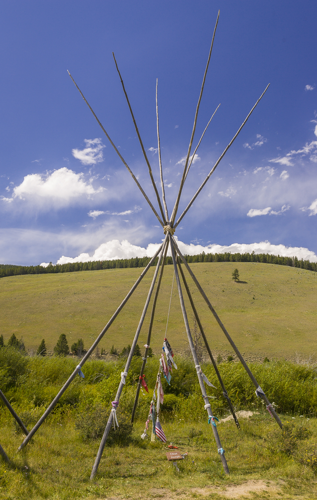 The poles of a tipi with cloths tied in some spots on a prairie at Big Hole National Battlefield in Montana.