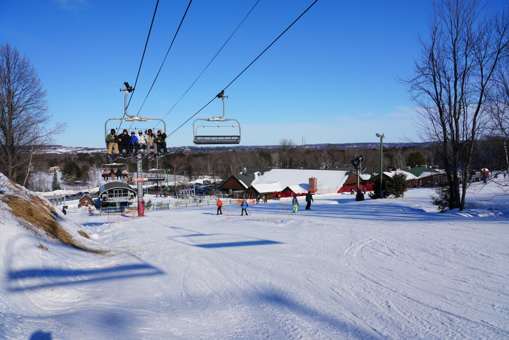 Sunny day at the Granite Peak Ski Area with people riding the chairlift in Wisconsin.