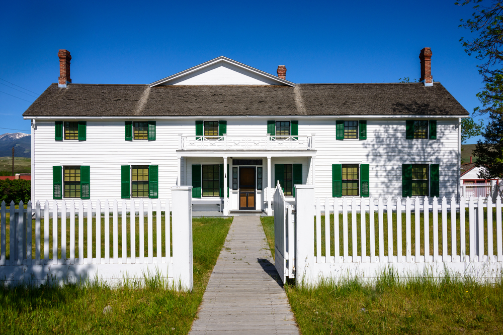 A white building a picket fence at the Grant-Kohrs Ranch in Montana.