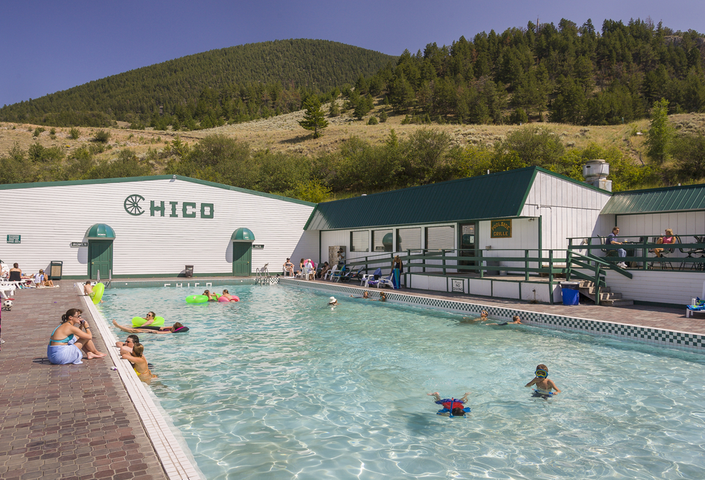 Families swimming at the Chico Hot Springs on a sunny day in Montana.