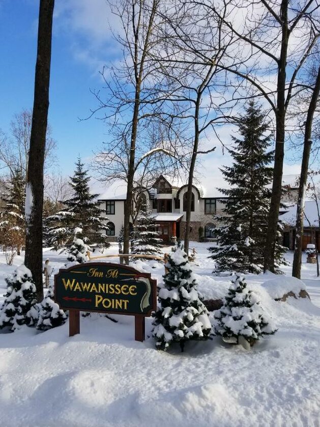 Snowy scene of the front of the Inn at Wawanissee Point in Wisconsin.