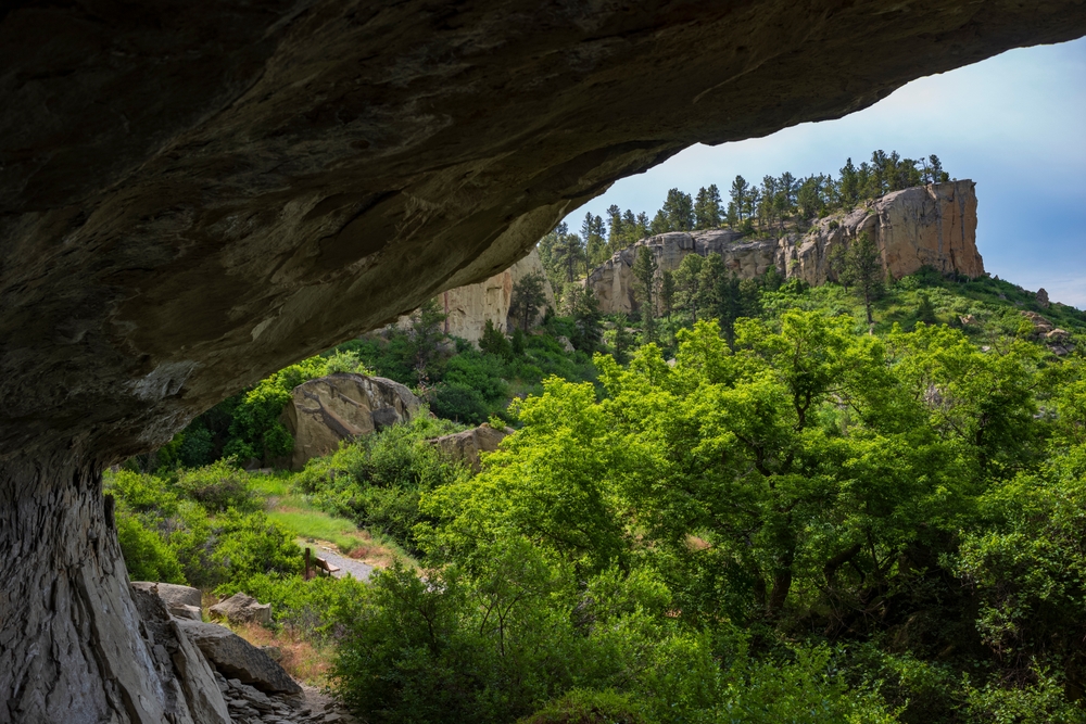 View looking out of one of the caves toward trees at Pictograph Cave State Park.