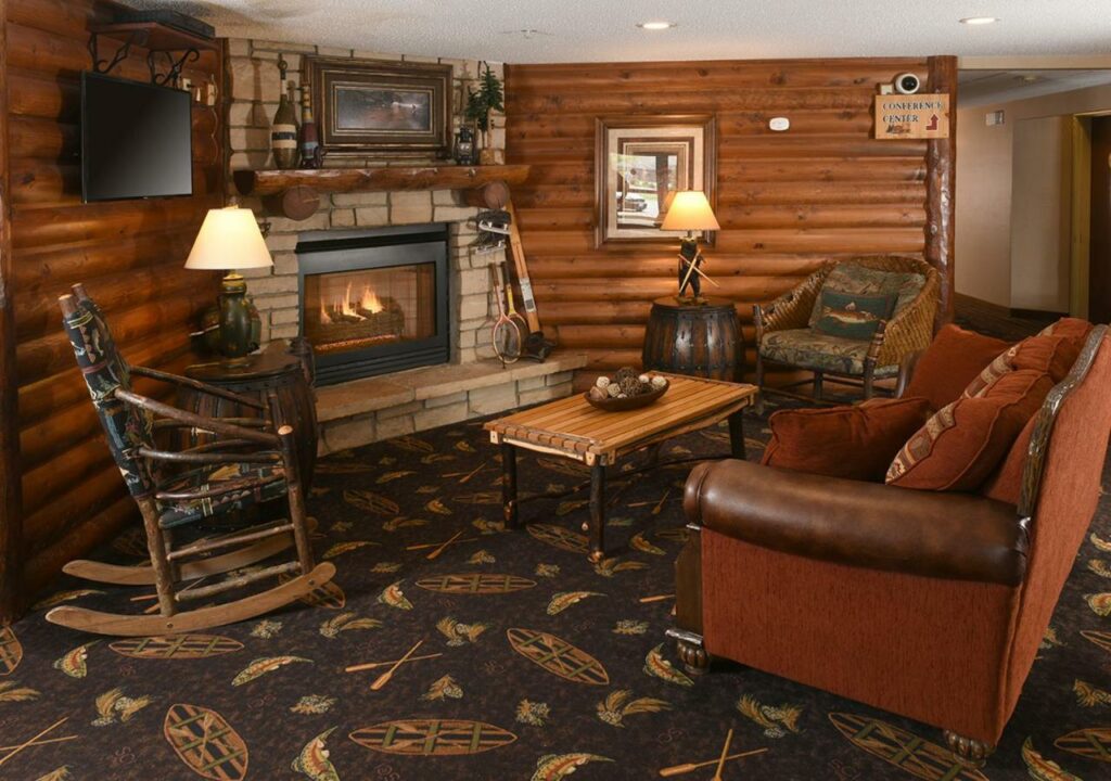 Comfy sitting area with fireplace and log walls at Stoney Creek Hotel, one of the best ski resorts in Wisconsin.