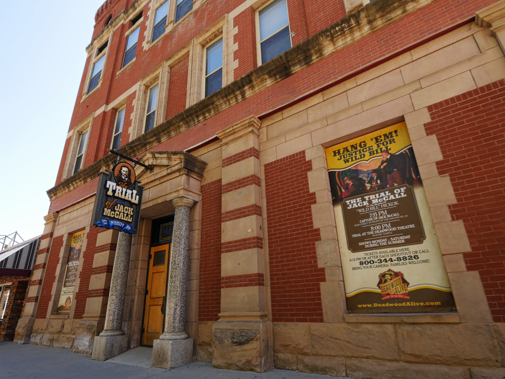 Old, brick building with signs for the Trial of Jack McCall.