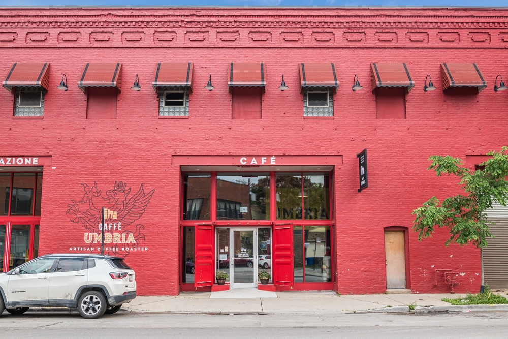 The front exterior of a painted red brick building that is one of the best coffee shops in Chicago, Caffe Umbria