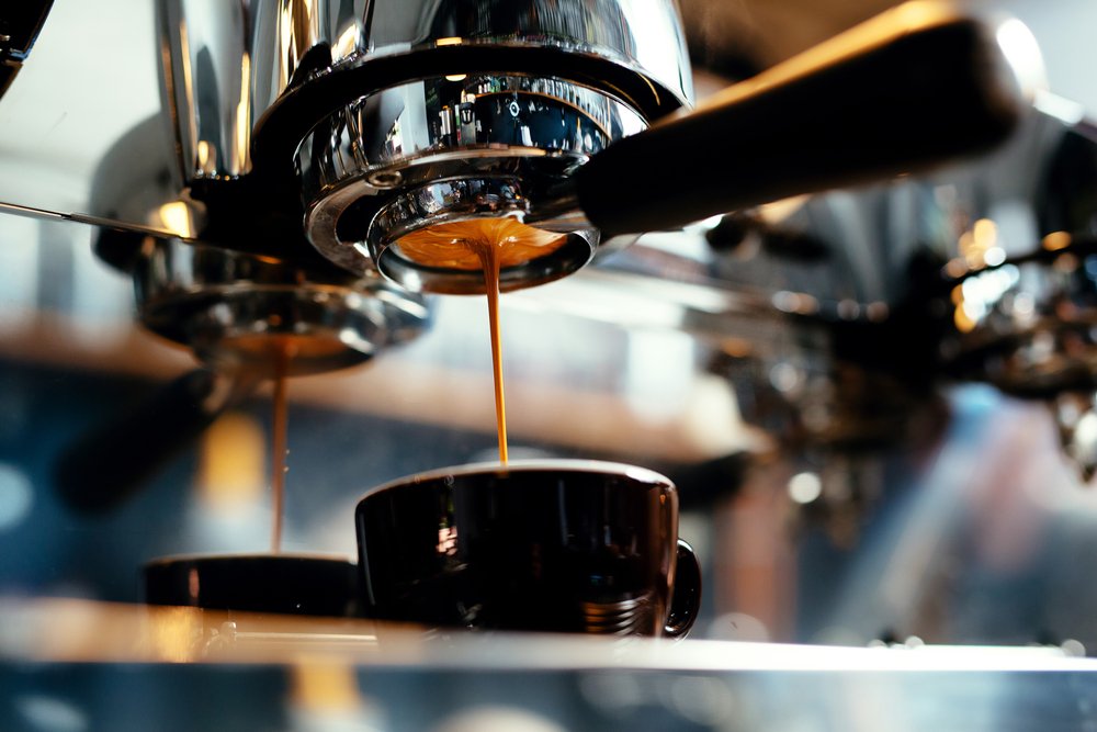 A close up of an espresso machine pouring espresso into a dark colored mug at one of the best coffee shops in Chicago