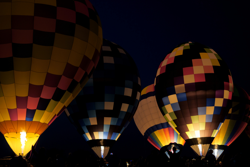 A group of multi colored hot air balloons at night at one of the best festivals in Ohio