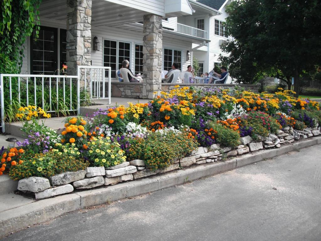 An inn surrounded with flowers with people sat on the terrace. One of the resorts in Door County. 
