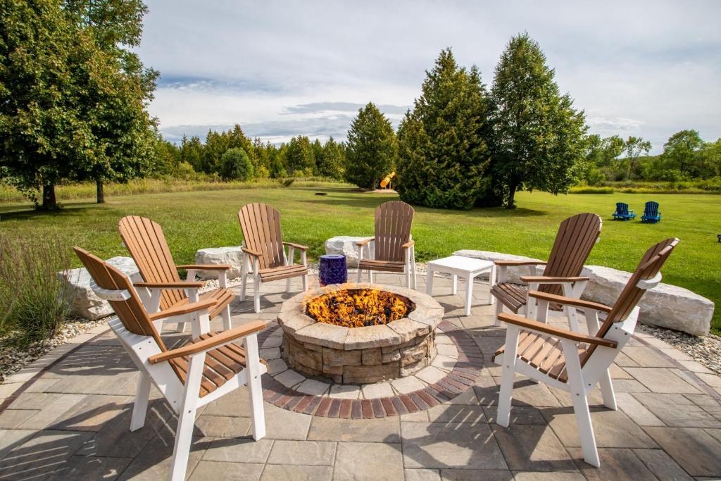 Outdoor firepit with chairs around and an expanse of woods in the background. 