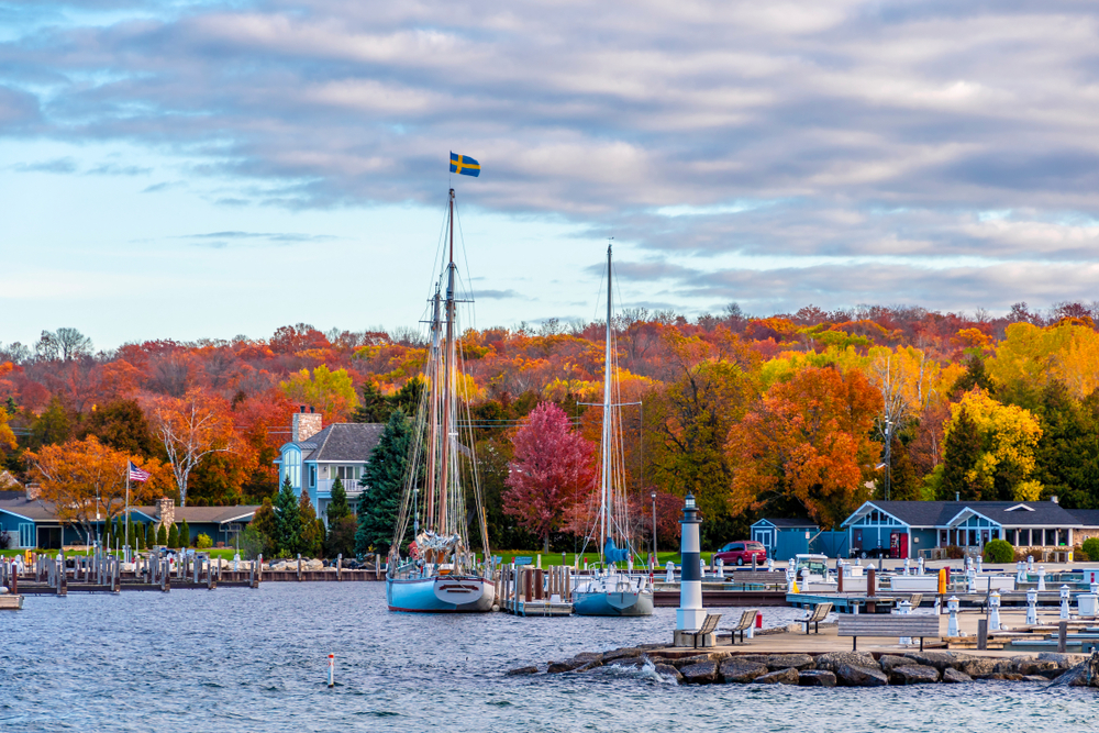 Sister Bay Town harbour view with fall colors in the background in an article about resorts in Door County. 