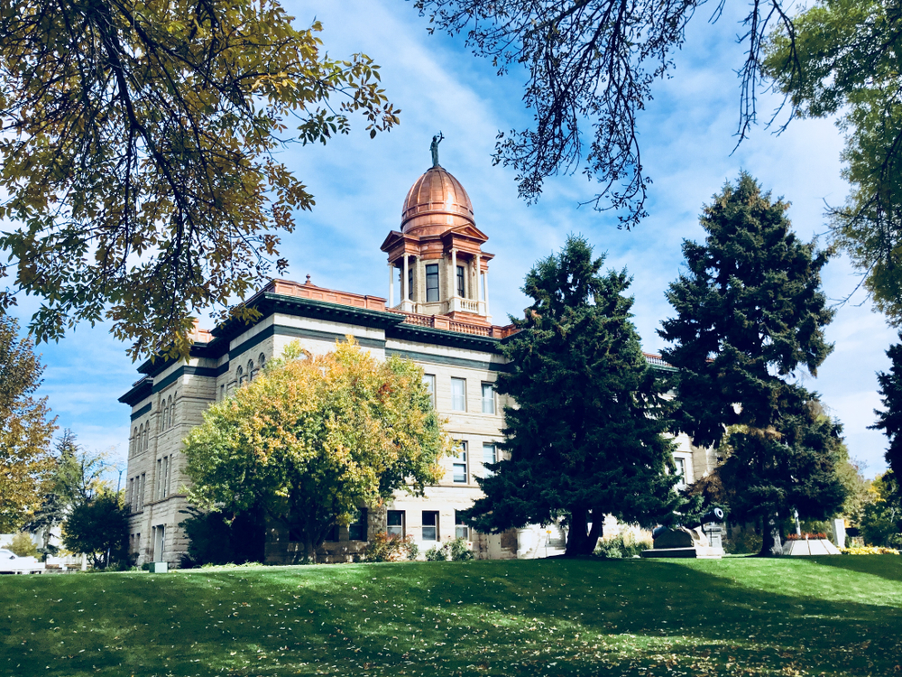 Exterior of the Cascade County Courthouse topped with a copper dome and surrounded by trees.