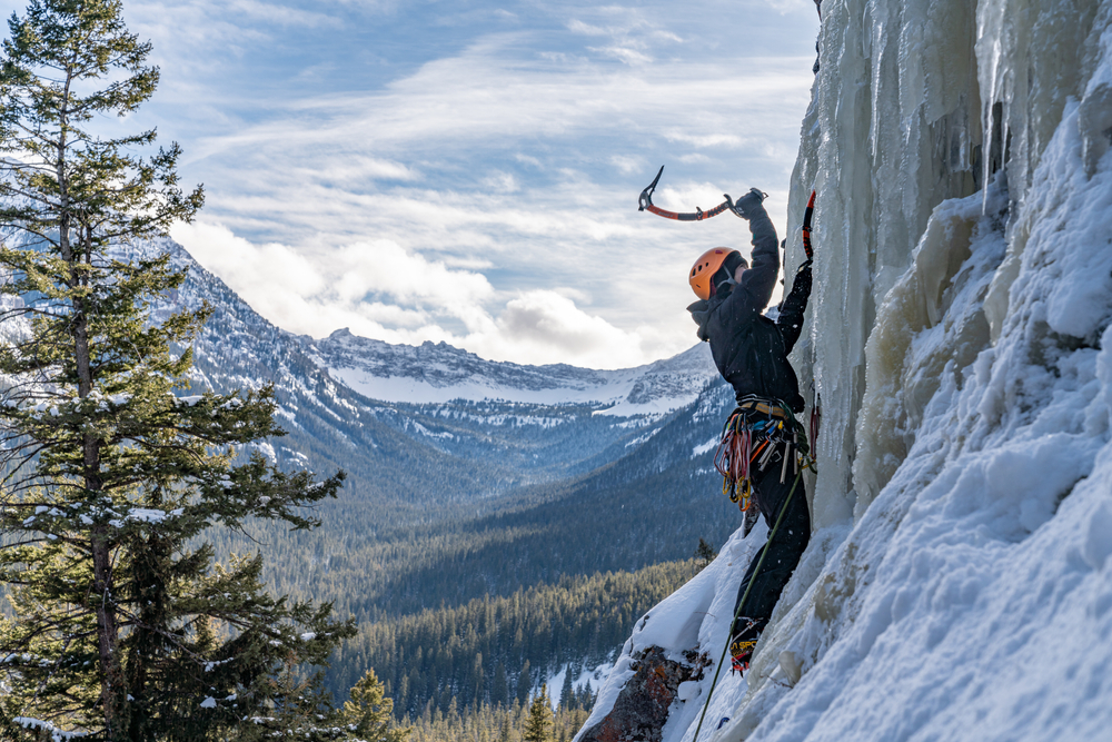 person using tools to ice climb winter in montana