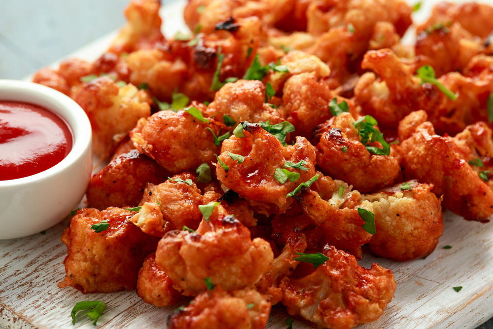 A tray full of fried cauliflower bites with a side of ketchup, similar to what you'll find at restaurants in Tulsa.