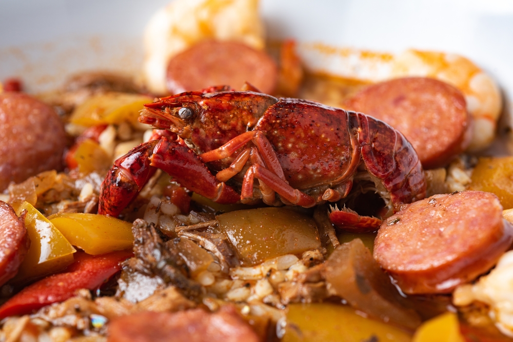 A close up image of a bowl of jambalaya with a crawfish, sausage, rice, and onions on it. It's similar to what you'll find at restaurants in Tulsa
