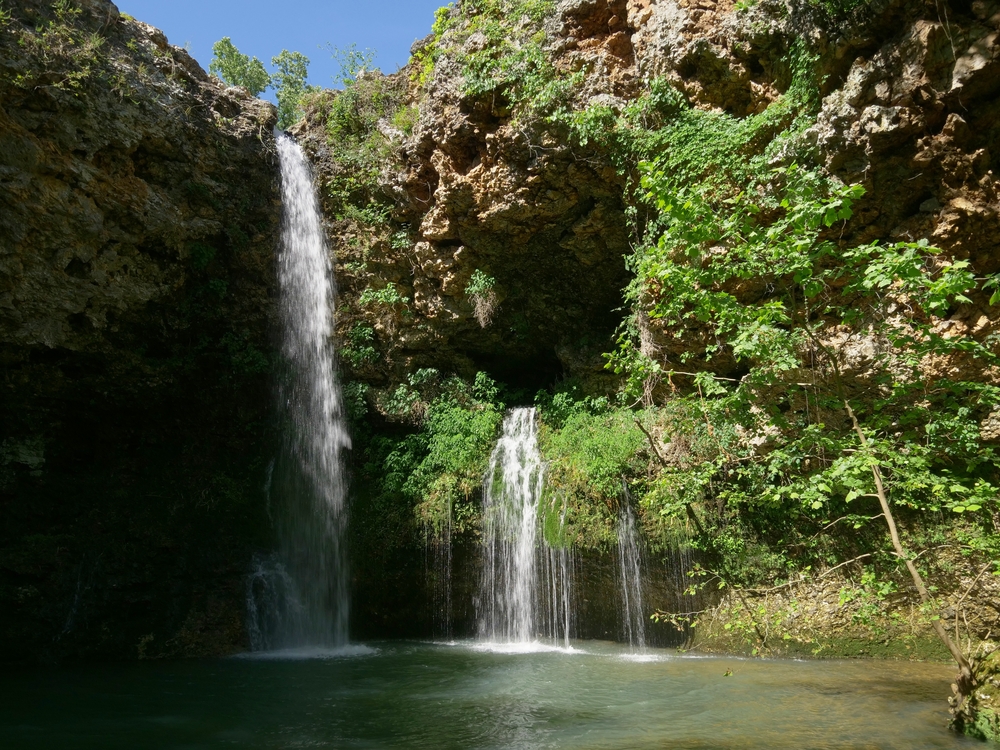 A couple of waterfalls cascading down a cliff in Natural Falls State Park seen while hiking in Oklahoma.