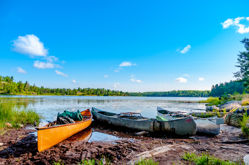 Three canoes on the shore of a lake in the Boundary Waters Canoe Area in the North Woods of Northern Minnesota