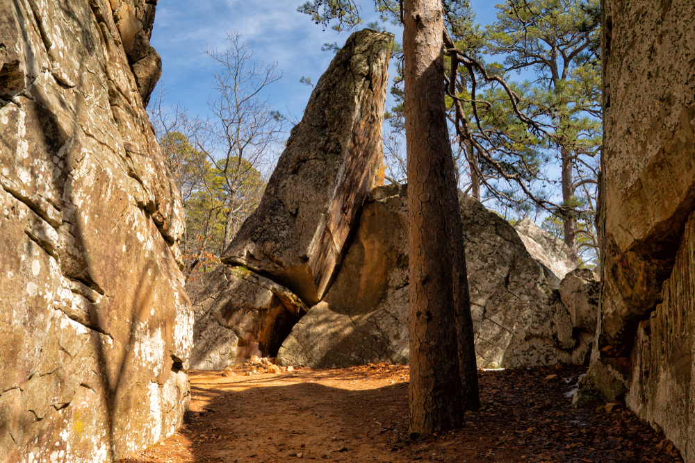 Dirt path going between large rock formations.