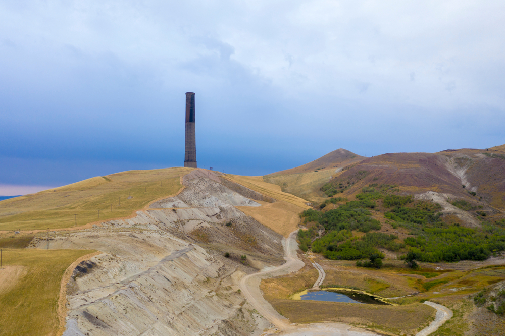 The tall Anaconda Smelter Stack sitting atop rolling hills.