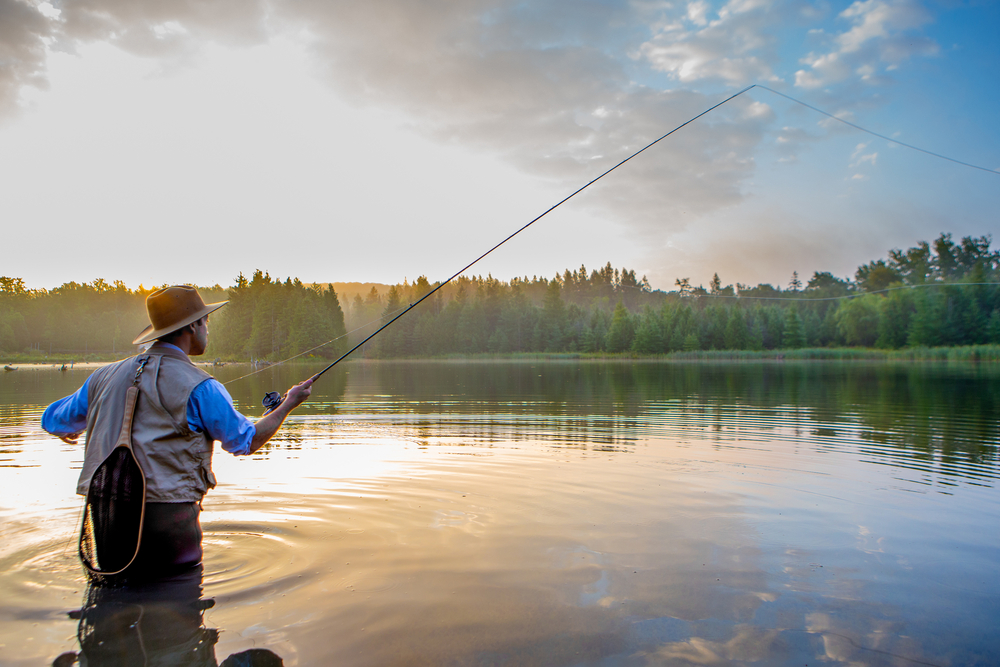 young man fly fishing in a lake