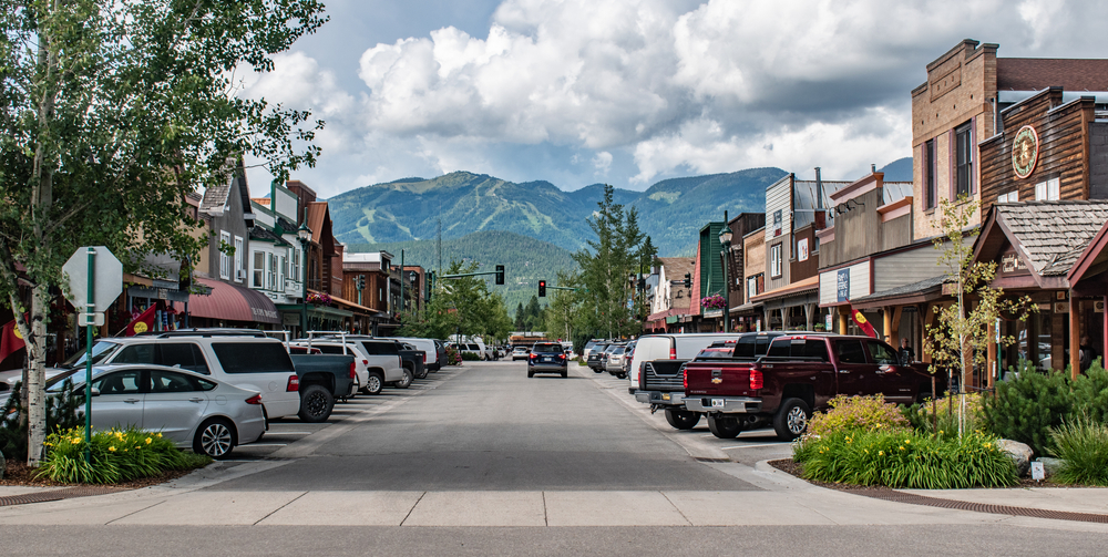 Looking down the downtown street of Whitefish with historic buildings and mountains in the distance.