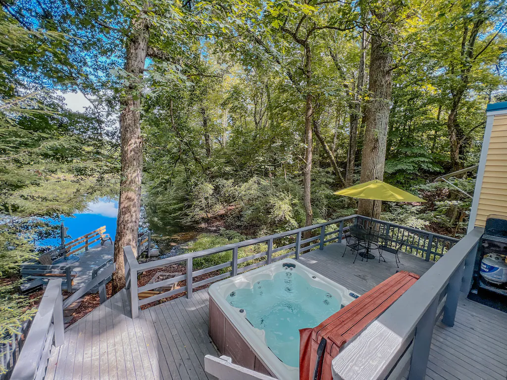 Hot tub on the deck with a walkway leading to an overlook.  