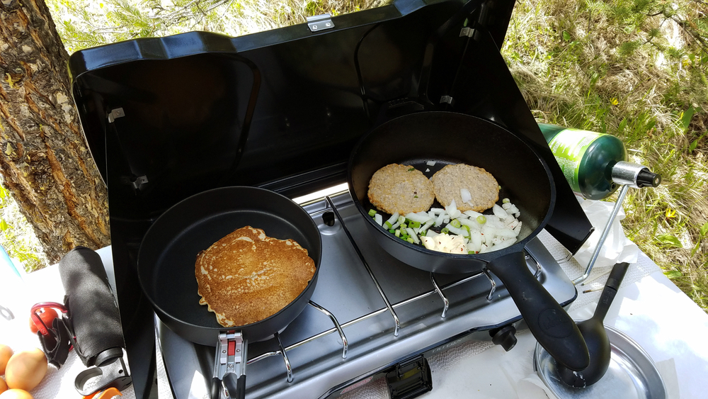 Breakfast cooking on a camp stove in a campsite in an article about camping in Montana.