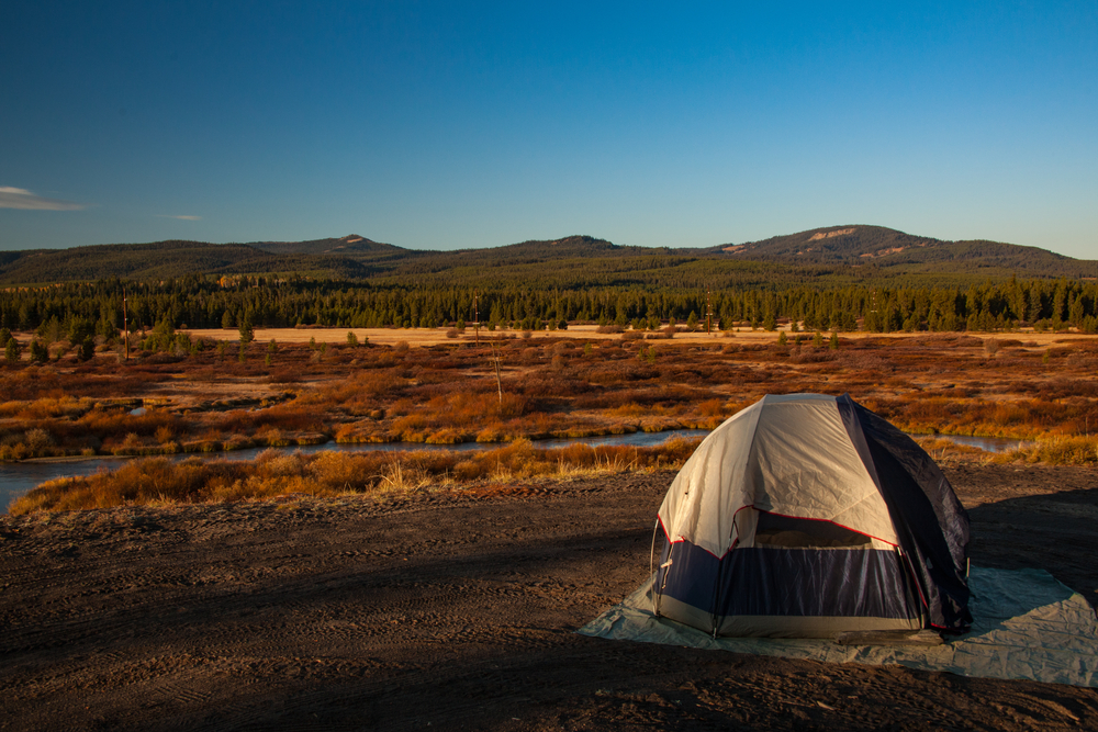 Camping near west yellowstone montana. Tent is isolation above a river. The article is about camping in Montana. 