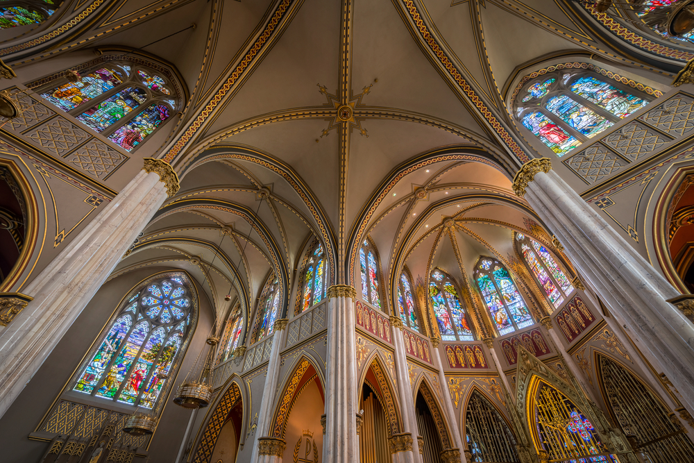 Inside the Cathedral of St. Helena looking up at the curved ceiling and stained glass windows.