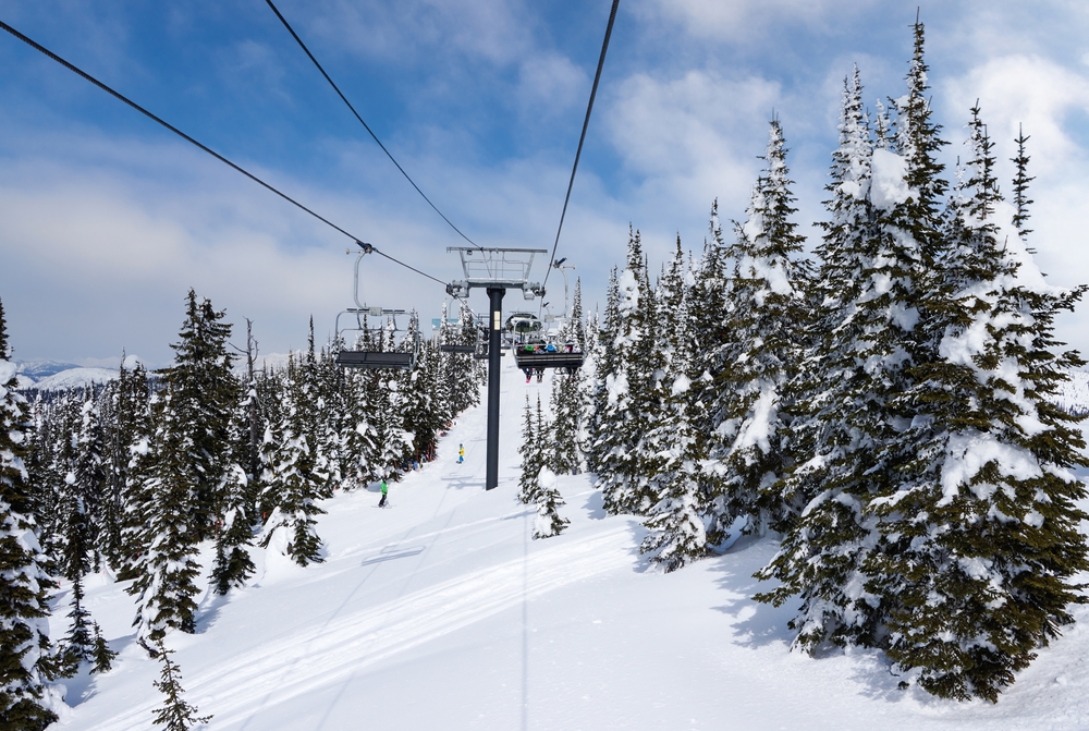 A ski lift surrounded by snow covered trees.