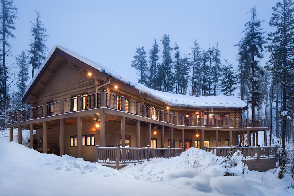 huge cabin covered with snow and surrounded by trees cabins in montana