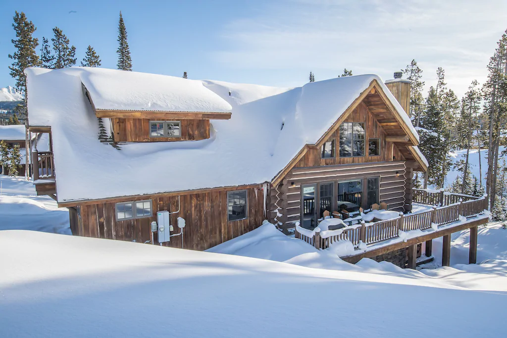 cabin with outer deck covered in snow