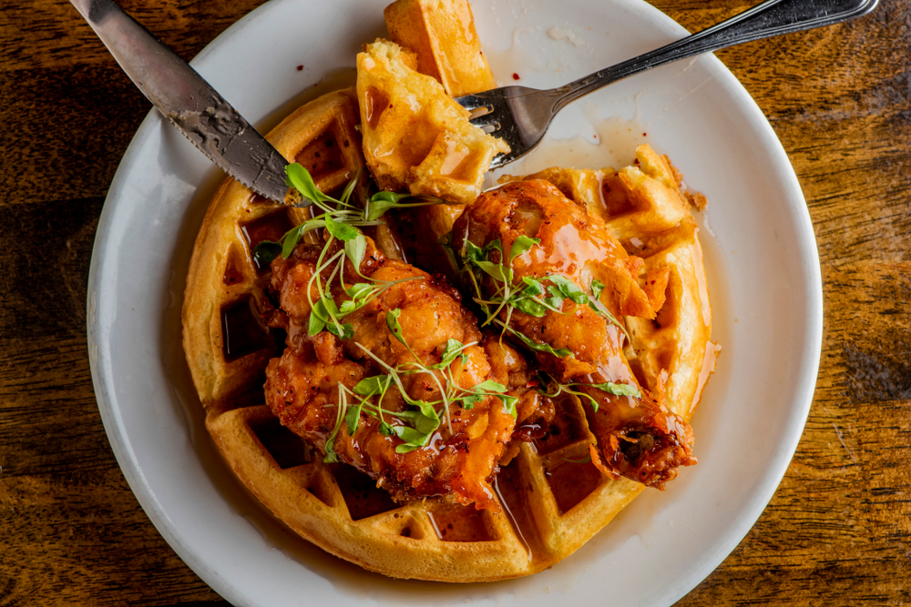 Chicken and waffles. Crispy homemade fried chicken on top of homemade buttermilk waffles topped with butter and maple syrup.